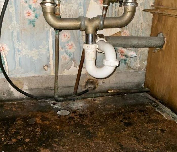 Kitchen sink has a broken pipe causing water to leak 