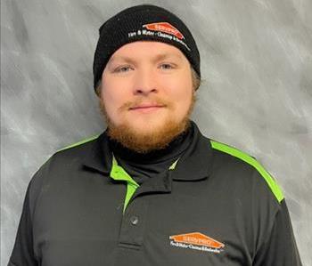 SERVPRO male employee standing in front of grey background